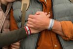 Both sides of Lebanon RAD Bracelets, one showing the Lebanese flag and the other the Arabic phrase "صَانَهُ رَبُّهُ لِمَدَى الْأَزْمَان."